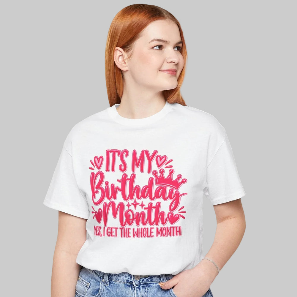 A woman with red hair wearing a white graphic t-shirt and light blue jeans, standing against a plain white background. The t-shirt features a pink graphic that reads 'IT'S MY Birthday Months BE I GET THE WHOLE MONTH'.