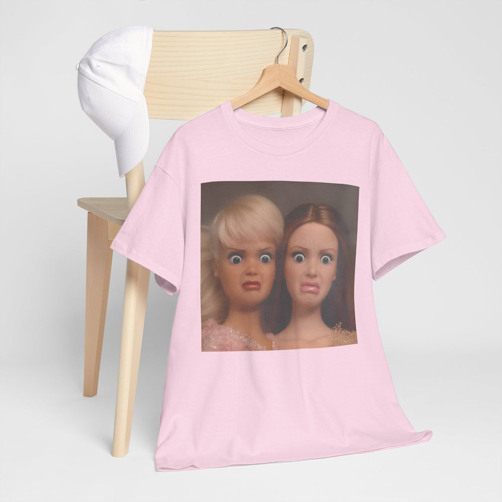 Pink t-shirt with a graphic of two dolls on a hanger against a white background