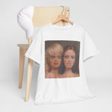 White t-shirt with a graphic of two dolls on a wooden chair against a white background