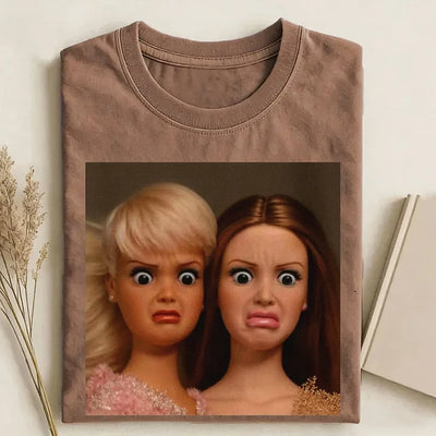Brown t-shirt with a graphic of two dolls on a light background