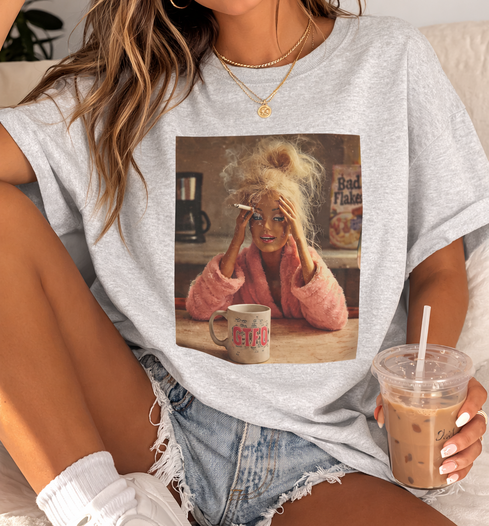 women wearing a funny  gray t-shirt with a graphic design of a woman with blonde hair and a coffee mug.